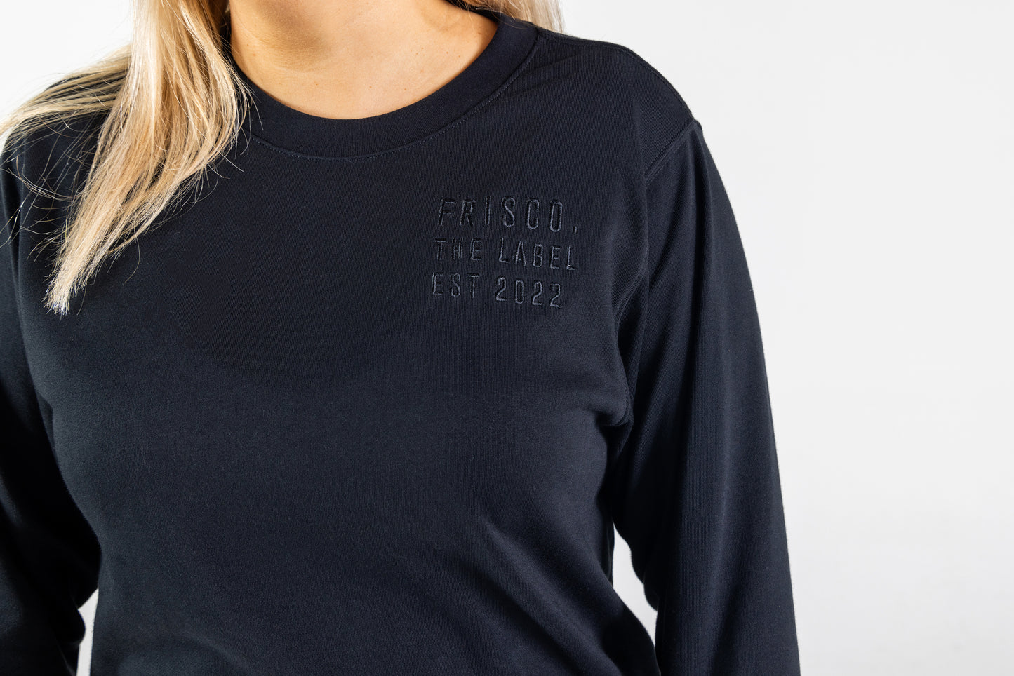 Frisco Women's activewear XL longsleeve crew top in black, closeup of black embroidery on chest that says Frisco, the label, est 2022