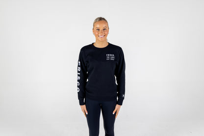 Frisco Women's activewear small longsleeve crew top in black with white embroidery, worn by smiling woman, shown from front